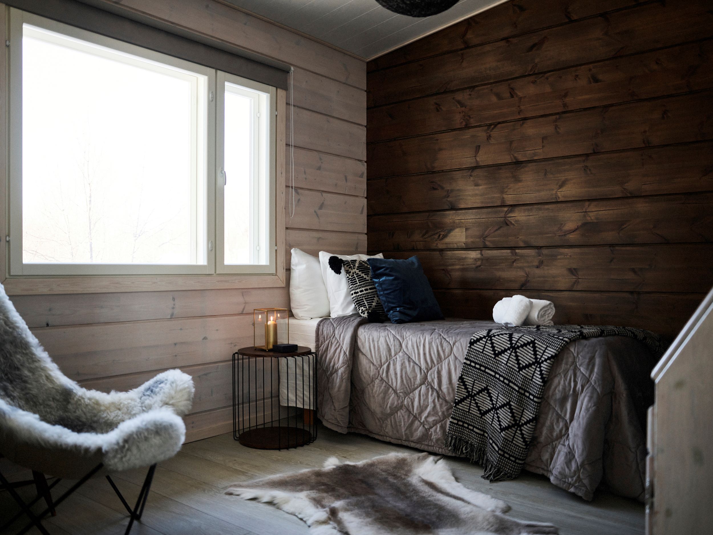 a room with a bed and reindeer hide on the floor, Lapland Luxury Hideaways