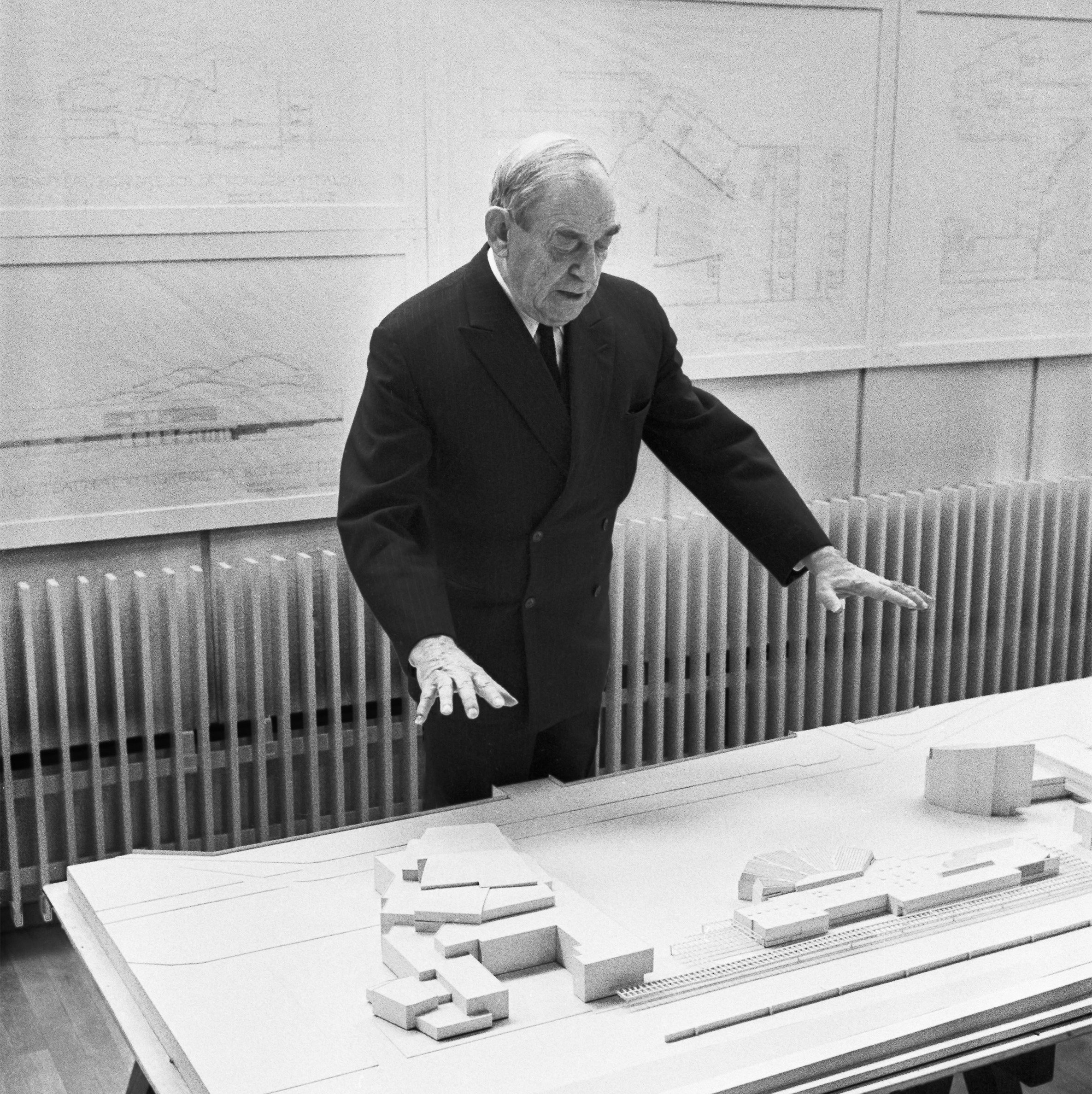 Architect Alvar Aalto standing next to the Rovaniemi Aalto Center scale model