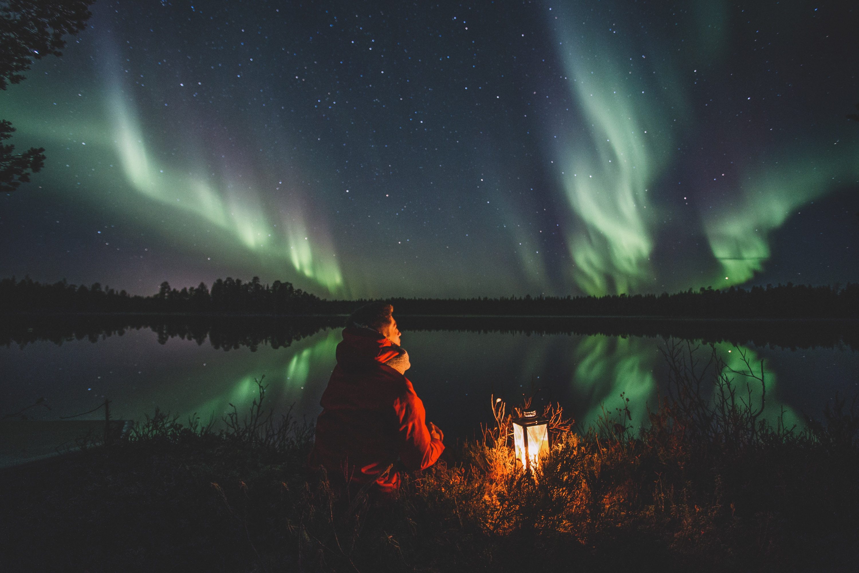 A person looking at Double Northern lights during autumn in Rovaniemi, Lapland, Finland.