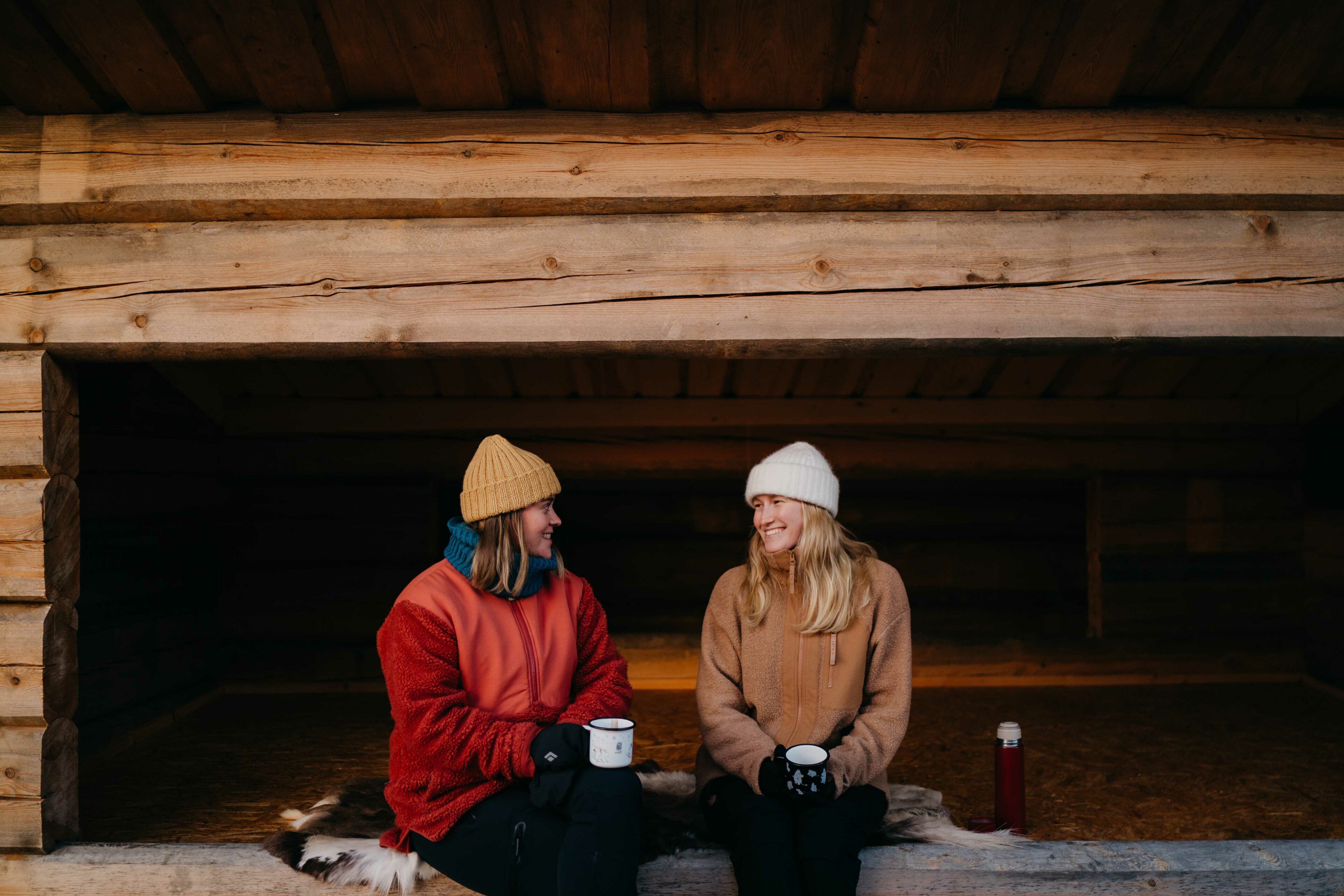 Two persons sitting in a lean-to during autumn in Rovaniemi, Lapland, Finland.