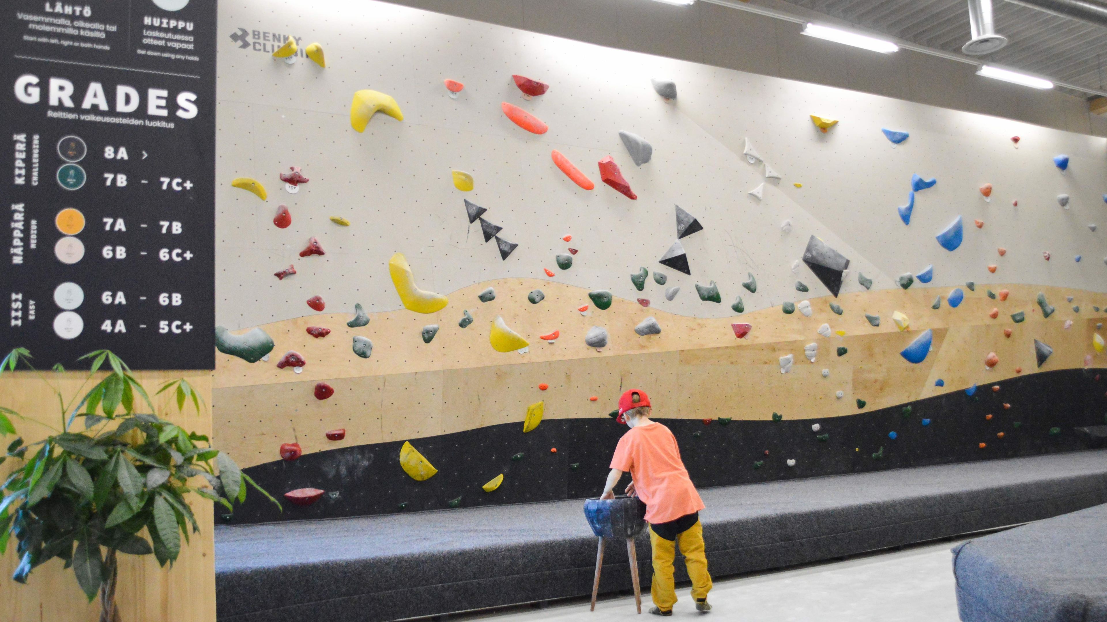 a child standing on a climbing wall in Väki climbing and Yoga center, Rovaniemi, Lapland, Finland