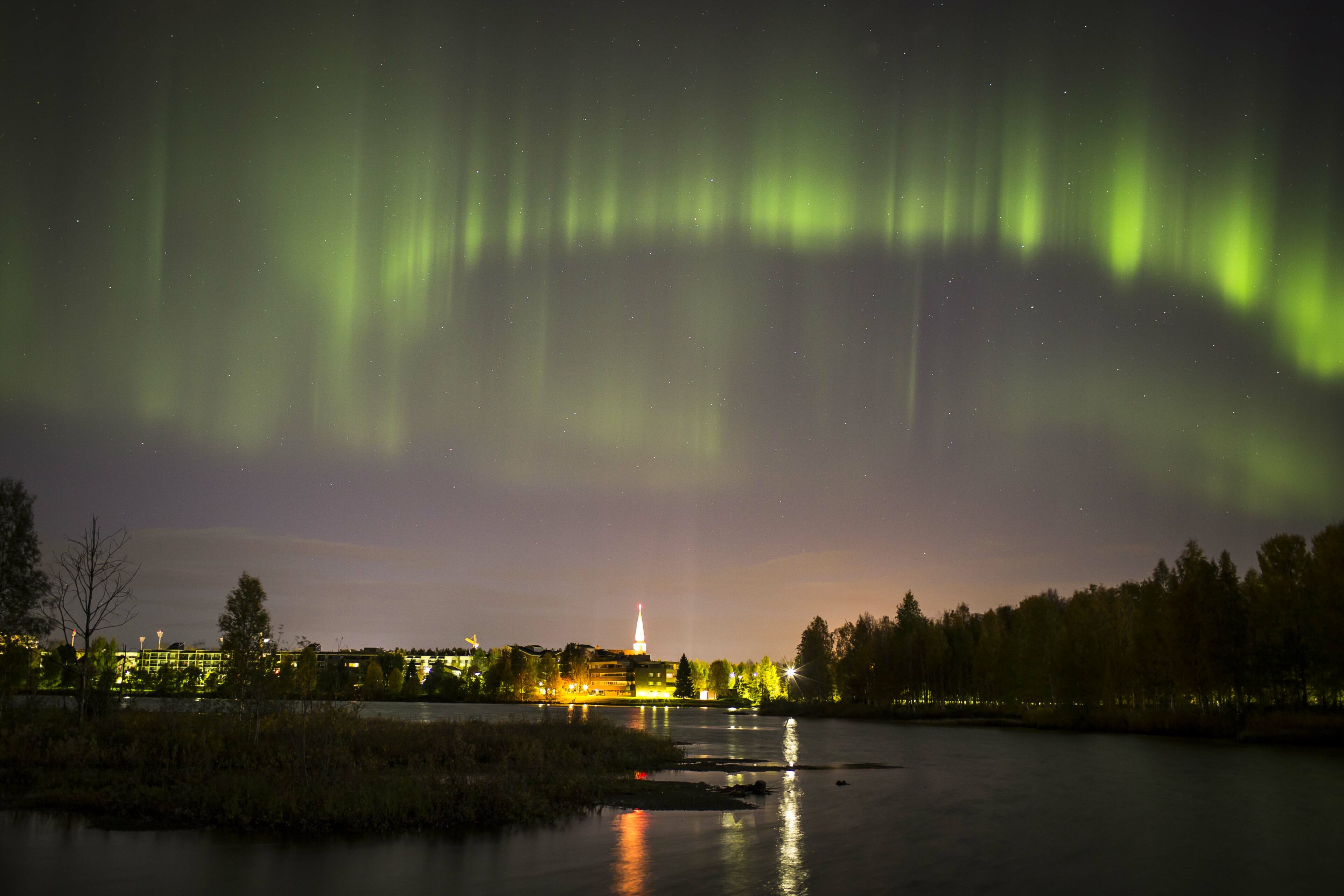 Green Northern Lights above Rovaniemi city centre in Lapland, Finland.