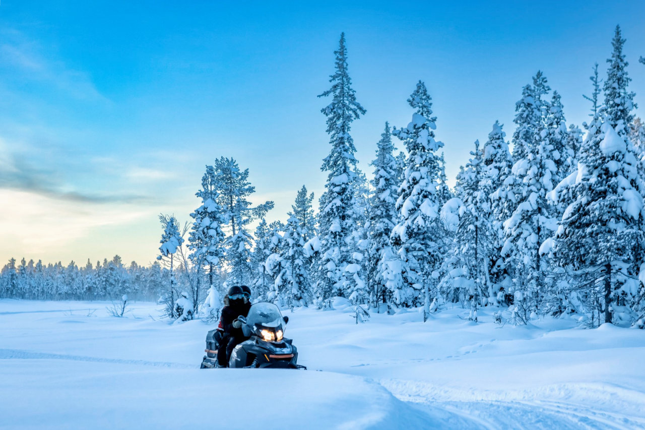 Snowmobiling in snow covered forest in Rovaniemi, Lapland, Finland, PolarMax Adventures