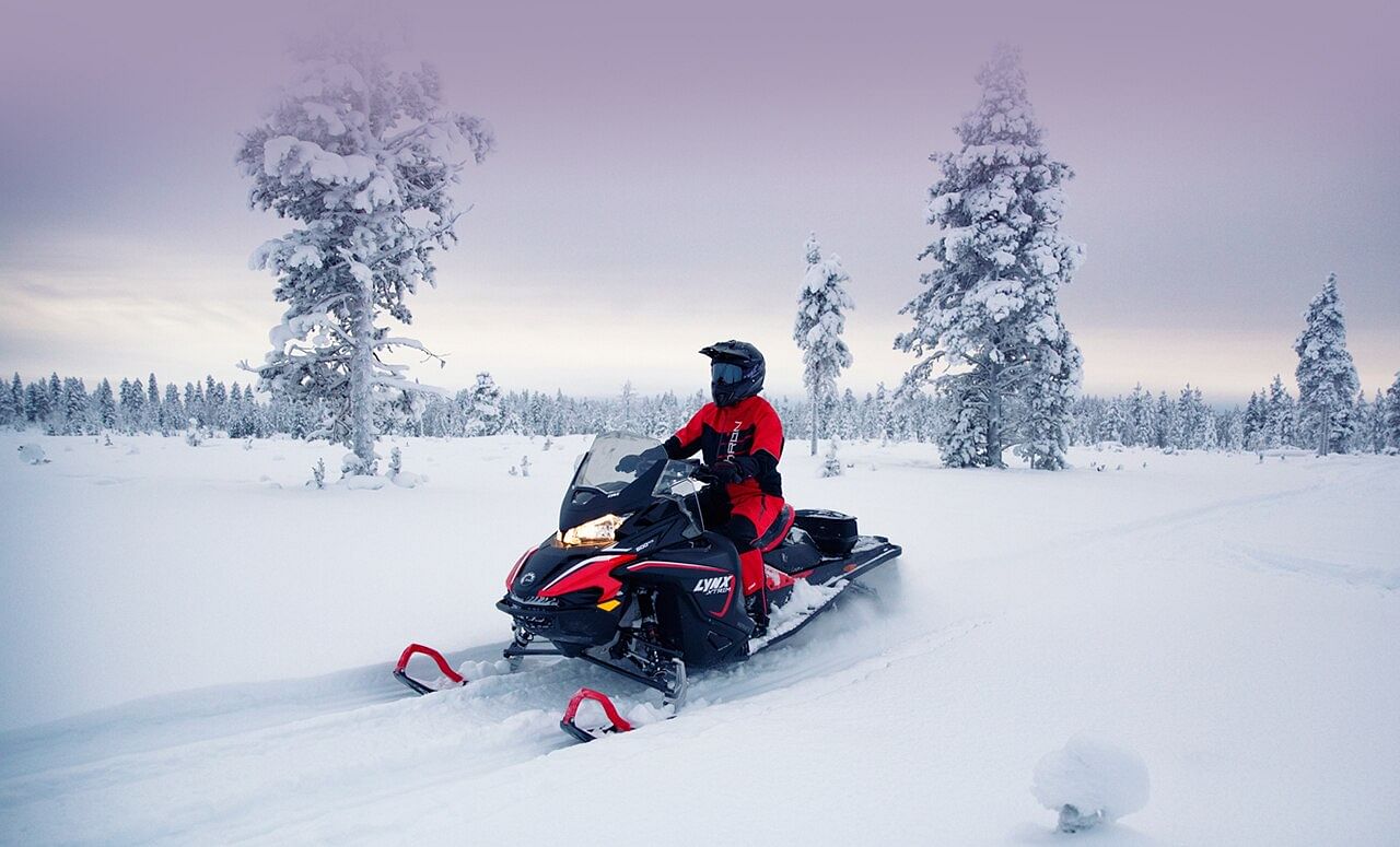 Snowmobiling in snow covered forest in Rovaniemi, Lapland, Finland, PolarMax Adventures