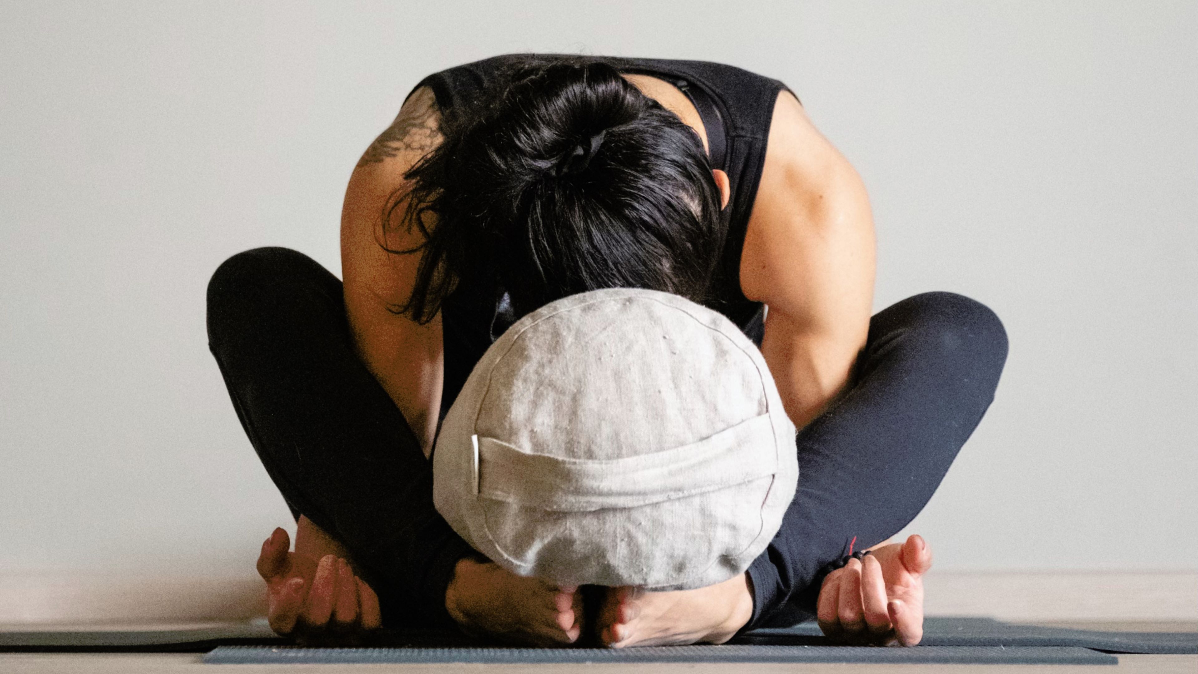 a woman sitting on the floor with her head on yoga bolster, Väki climbing and yoga center, Rovaniemi, Lapland, Finland